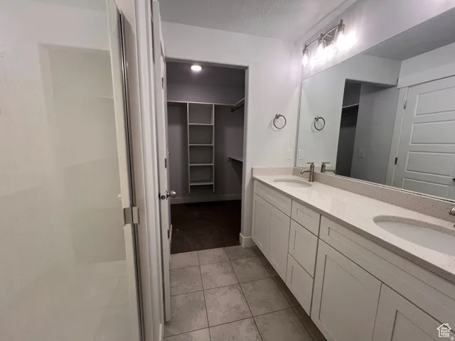Dual vanity with light-toned countertop, brushed nickel fixtures, and extensive mirror