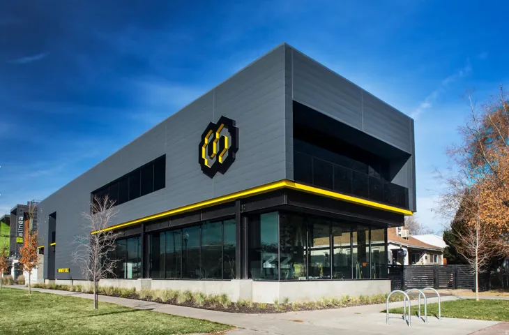 Contemporary commercial building featuring a gray panel facade with yellow accents