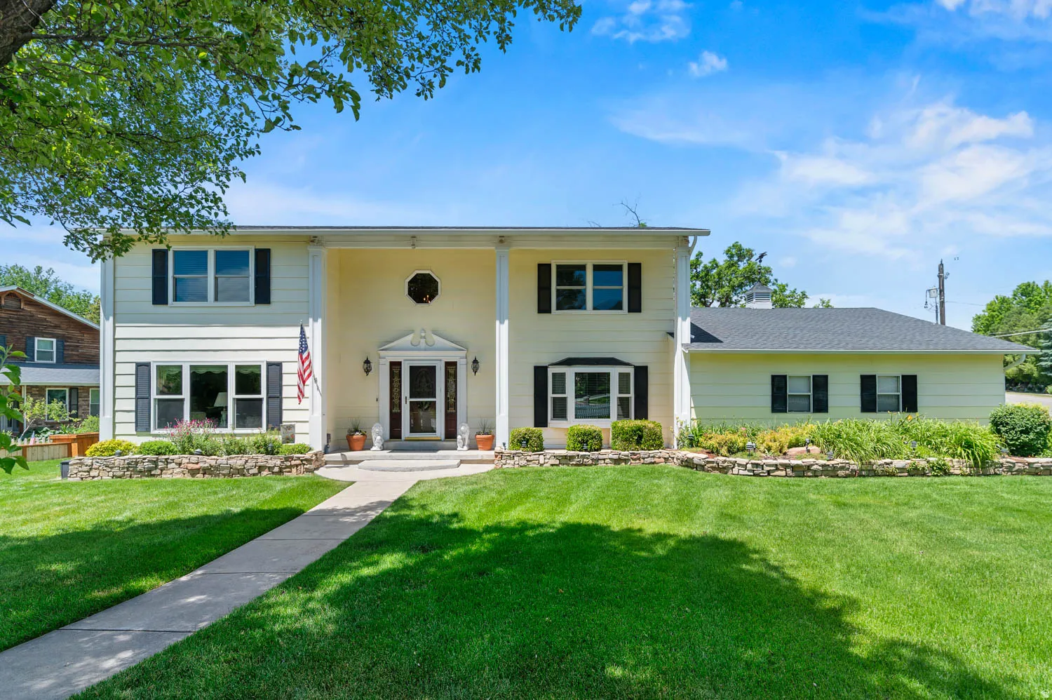 Traditional-style home featuring a prominent portico with columns, a detailed front entry, and a symmetrical facade