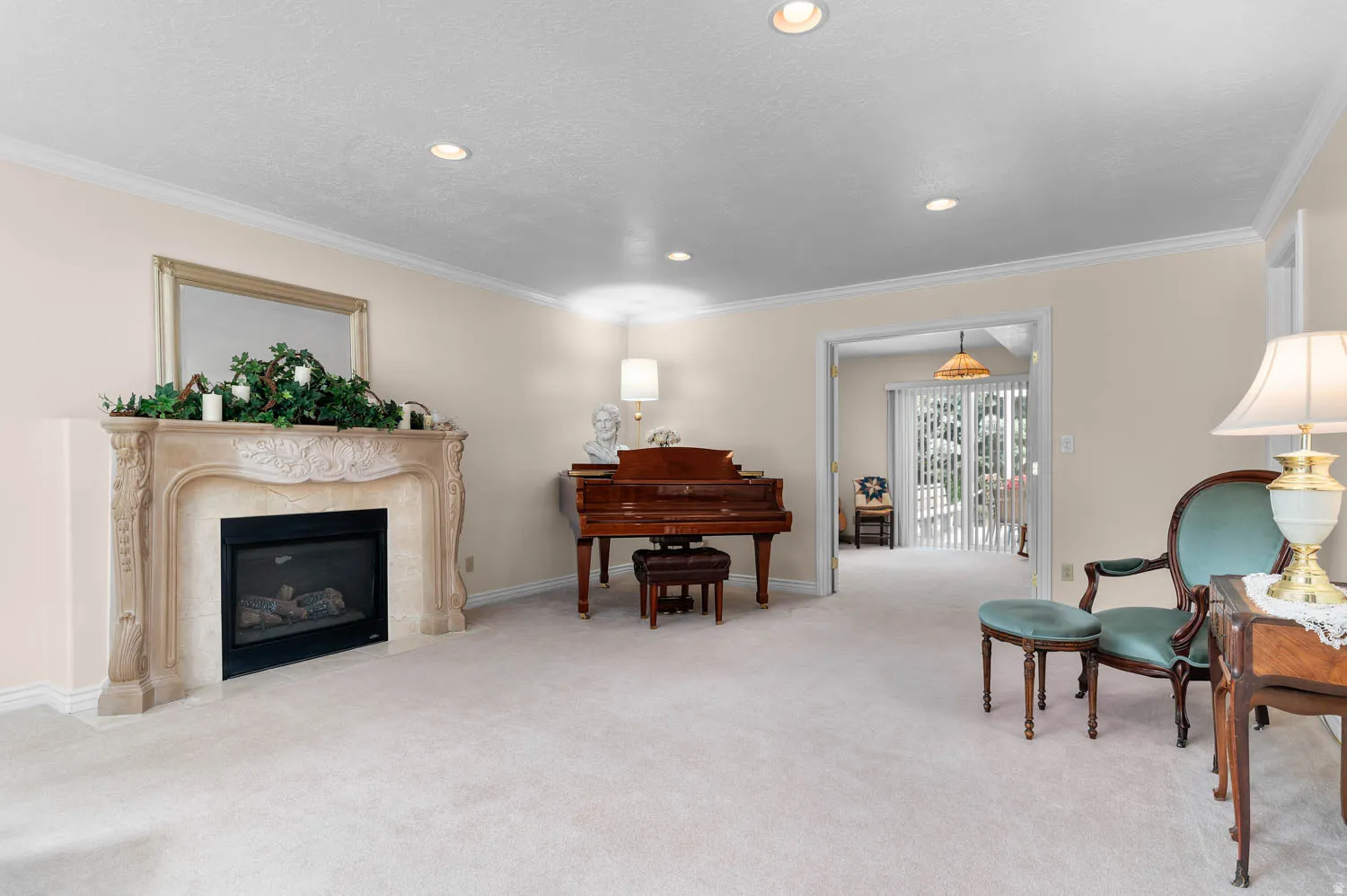 Formal living area featuring a decorative stone fireplace with a black insert