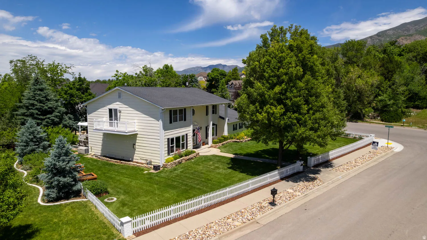 Two-story residence with light-colored siding and dark shingled roof