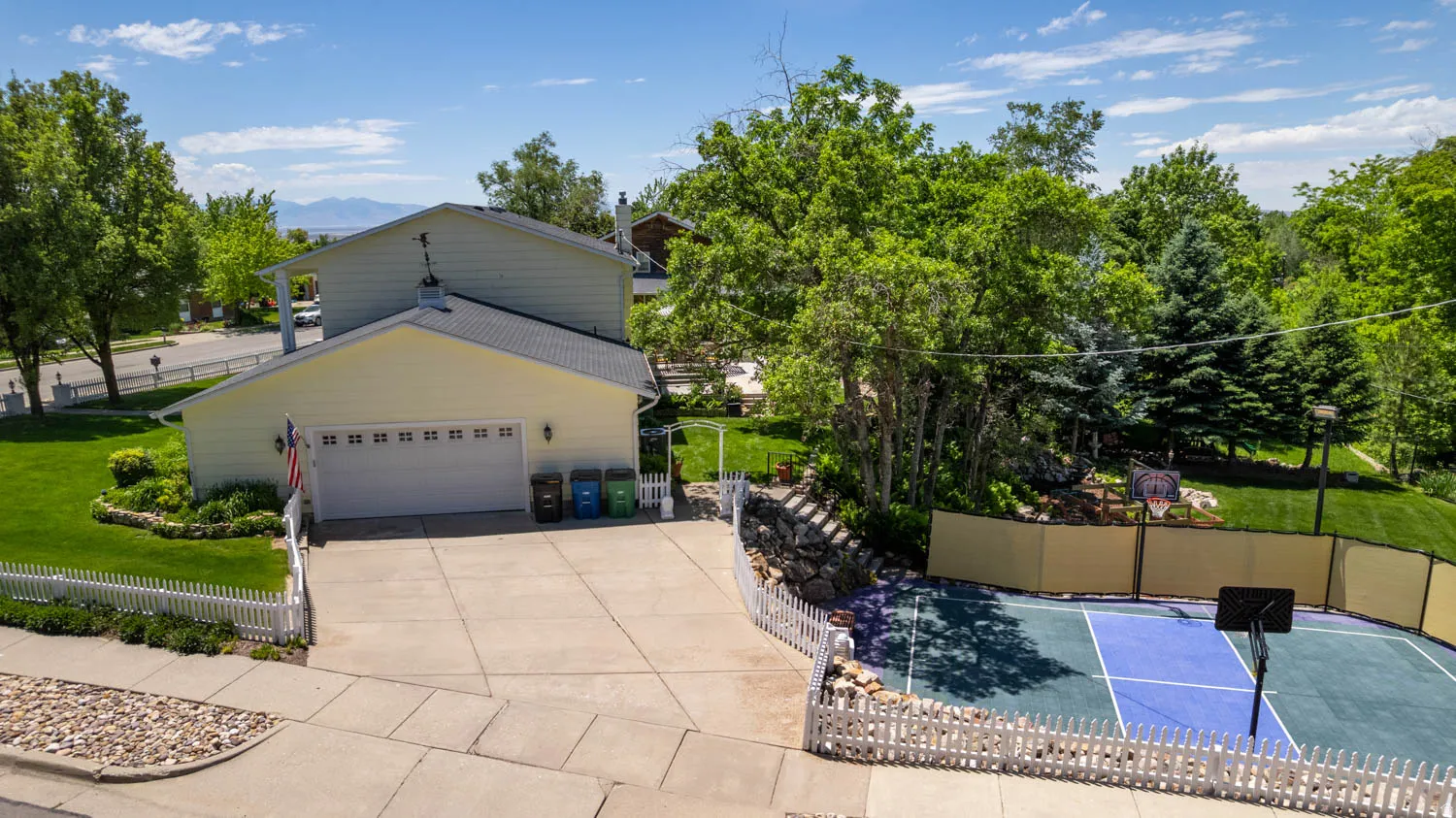 Spacious concrete driveway leading to an attached two-car garage