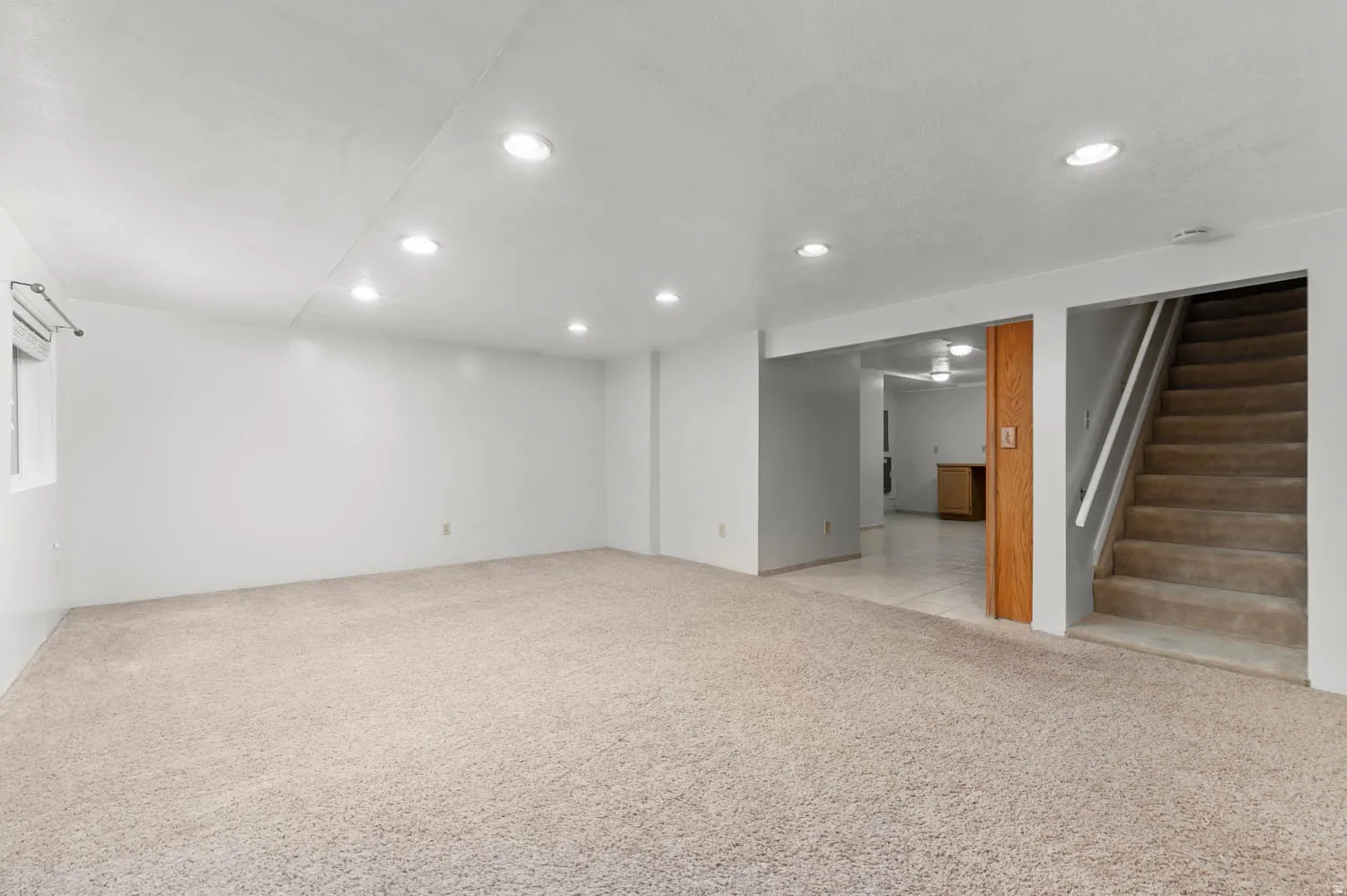 Spacious room with plush carpet flooring, recessed lighting, and a neutral color palette