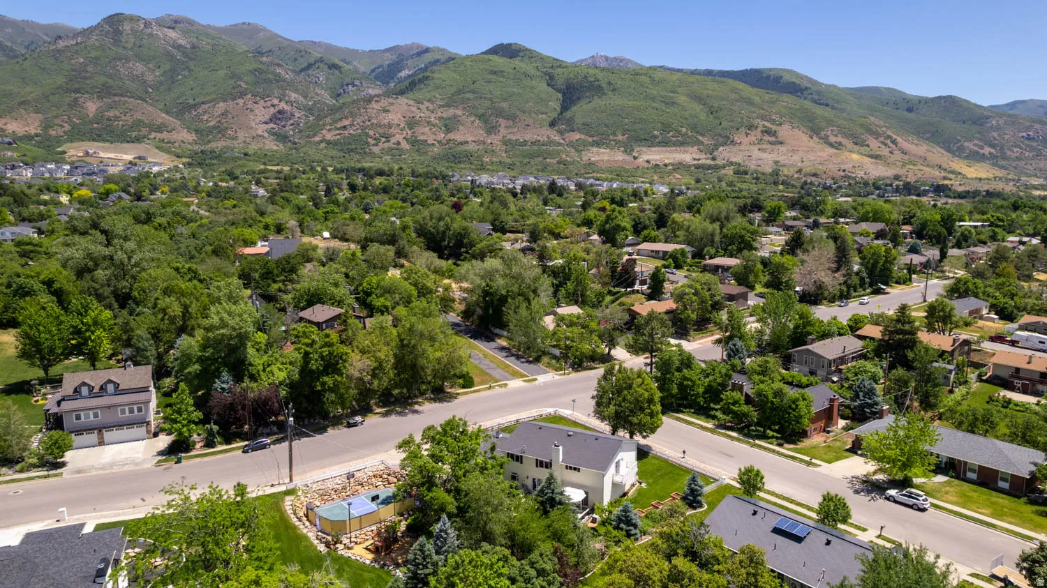 Residential neighborhood featuring mature trees and mountain backdrops