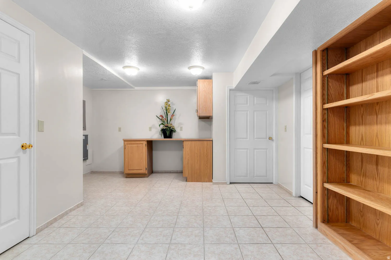 Spacious room featuring light-toned tile flooring and recessed lighting
