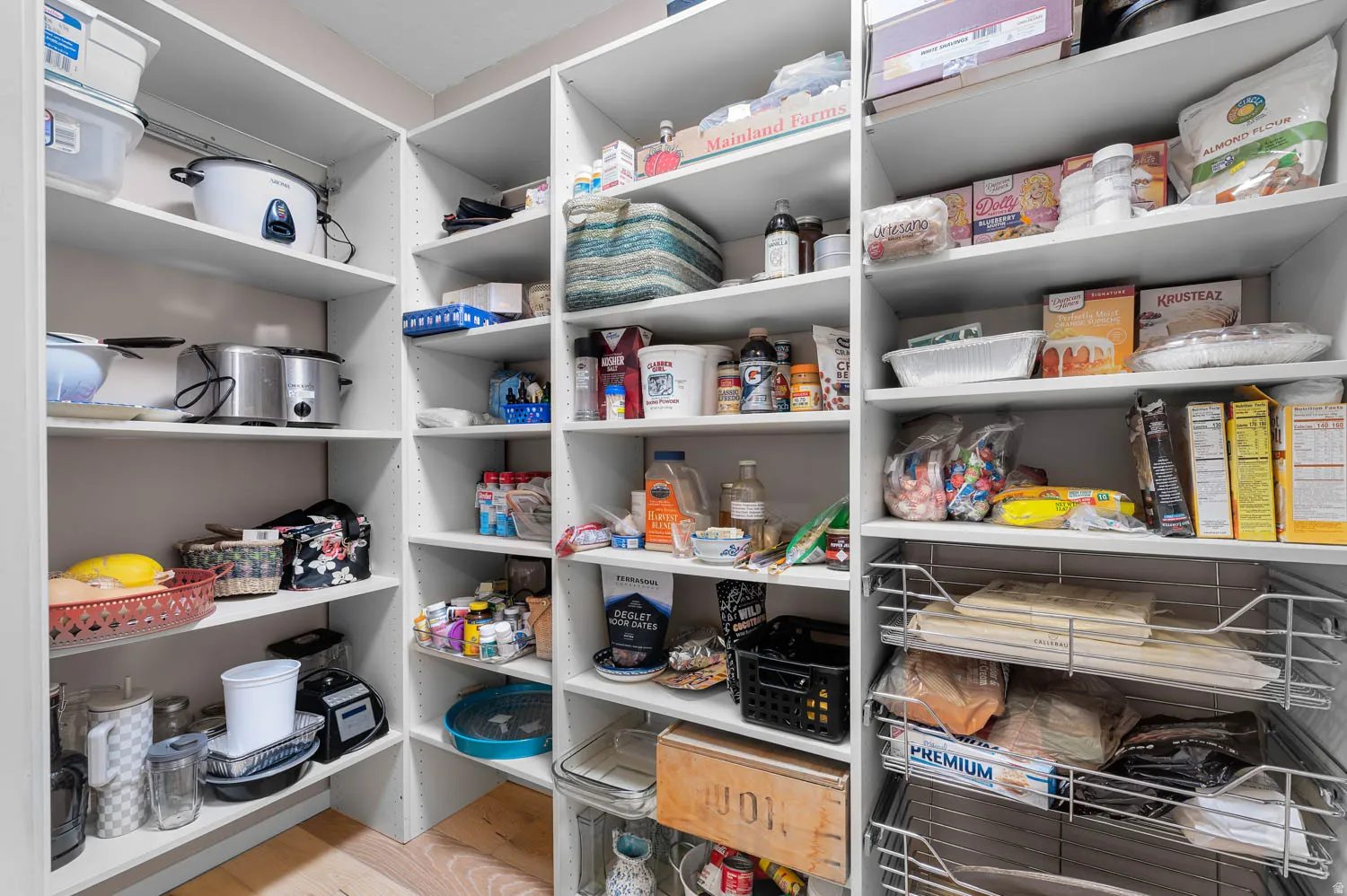 Spacious pantry featuring white built-in shelving, providing extensive storage options