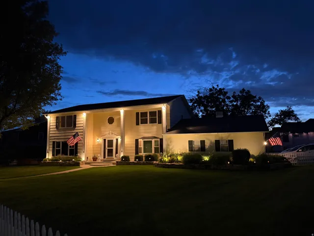 Traditional-style residence featuring a prominent front entrance with sidelights, transom window, and dual columns