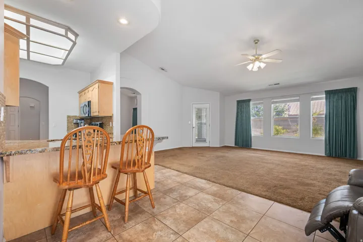 Kitchen island with a granite-style countertop and integrated breakfast bar