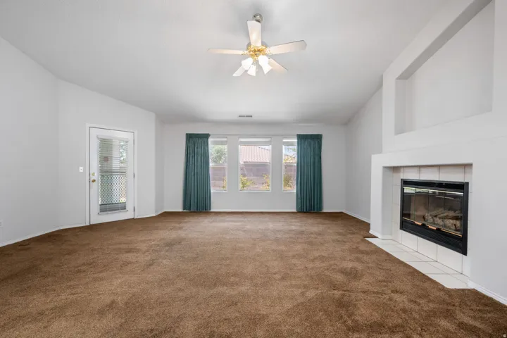 Living space featuring a gas fireplace with a tiled hearth and a high vaulted ceiling