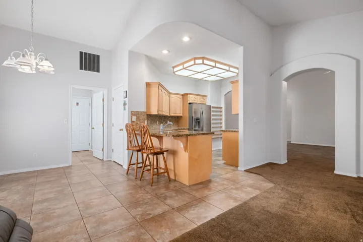 Kitchen featuring oak cabinetry, granite countertops, tile backsplash, and stainless steel appliances