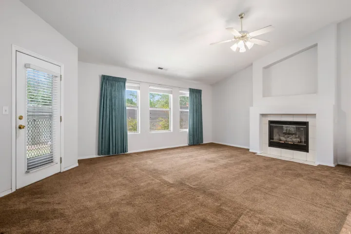 Living area featuring a fireplace with a white mantel and tile surround