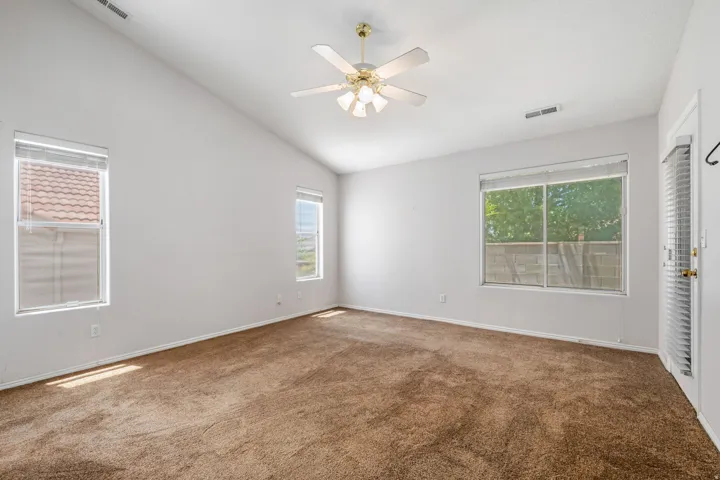 Room featuring vaulted ceilings and a ceiling fan with integrated lighting