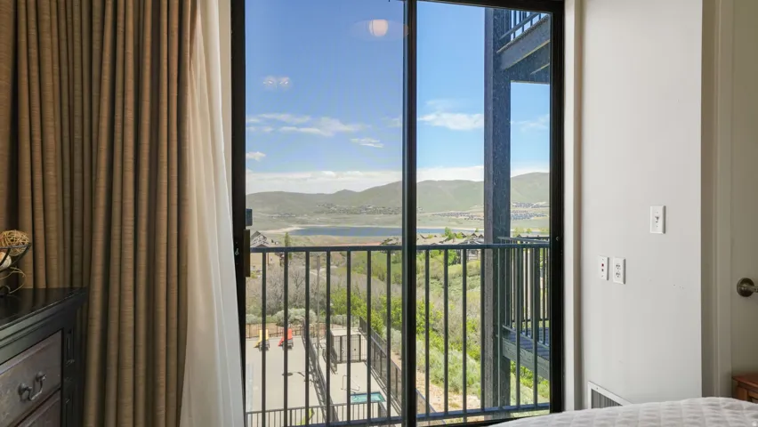 Sliding glass door leading to a private outdoor balcony with black wrought iron railing