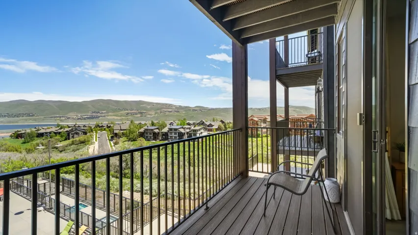 Private balcony featuring wood-finish decking and black metal railings
