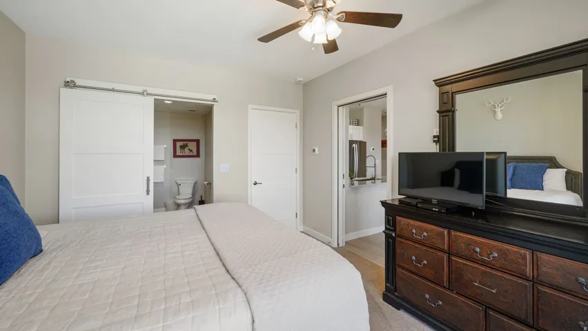 Room featuring neutral wall tones, a ceiling fan with integrated lighting, and carpeted flooring