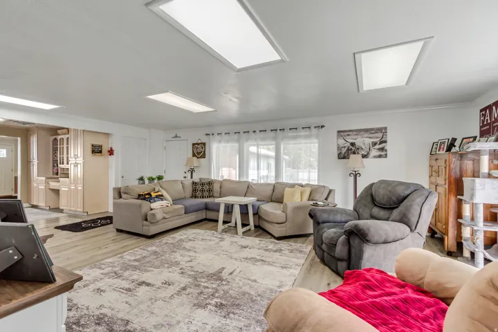 Spacious living area featuring wood-finish flooring, recessed ceiling lighting, and crown molding