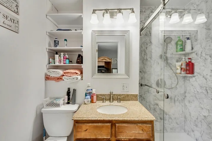 Bathroom vanity with a granite countertop, undermount sink, and wood-finish cabinetry