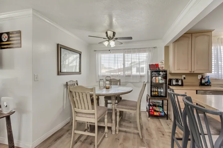 Dining area featuring wood-finish flooring and crown molding