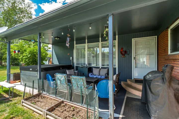 Covered patio with a dark grey ceiling and support columns