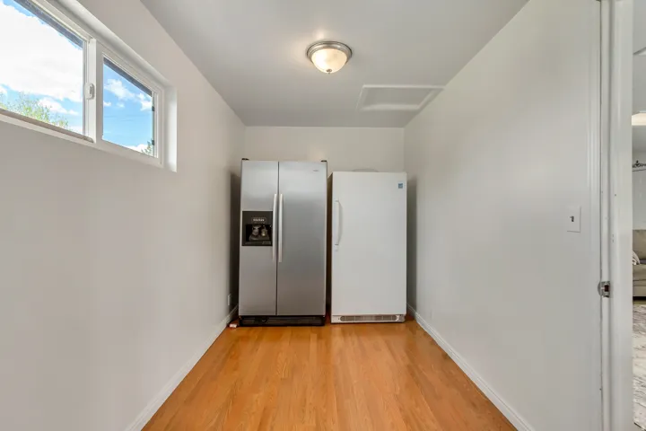 Utility area featuring wood-finish flooring, white walls, and a ceiling-mounted light fixture