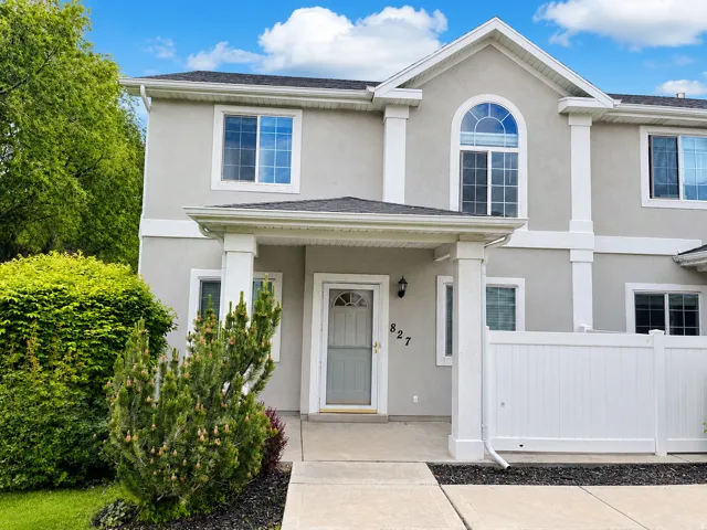 Stucco exterior with white trim details and a covered entry