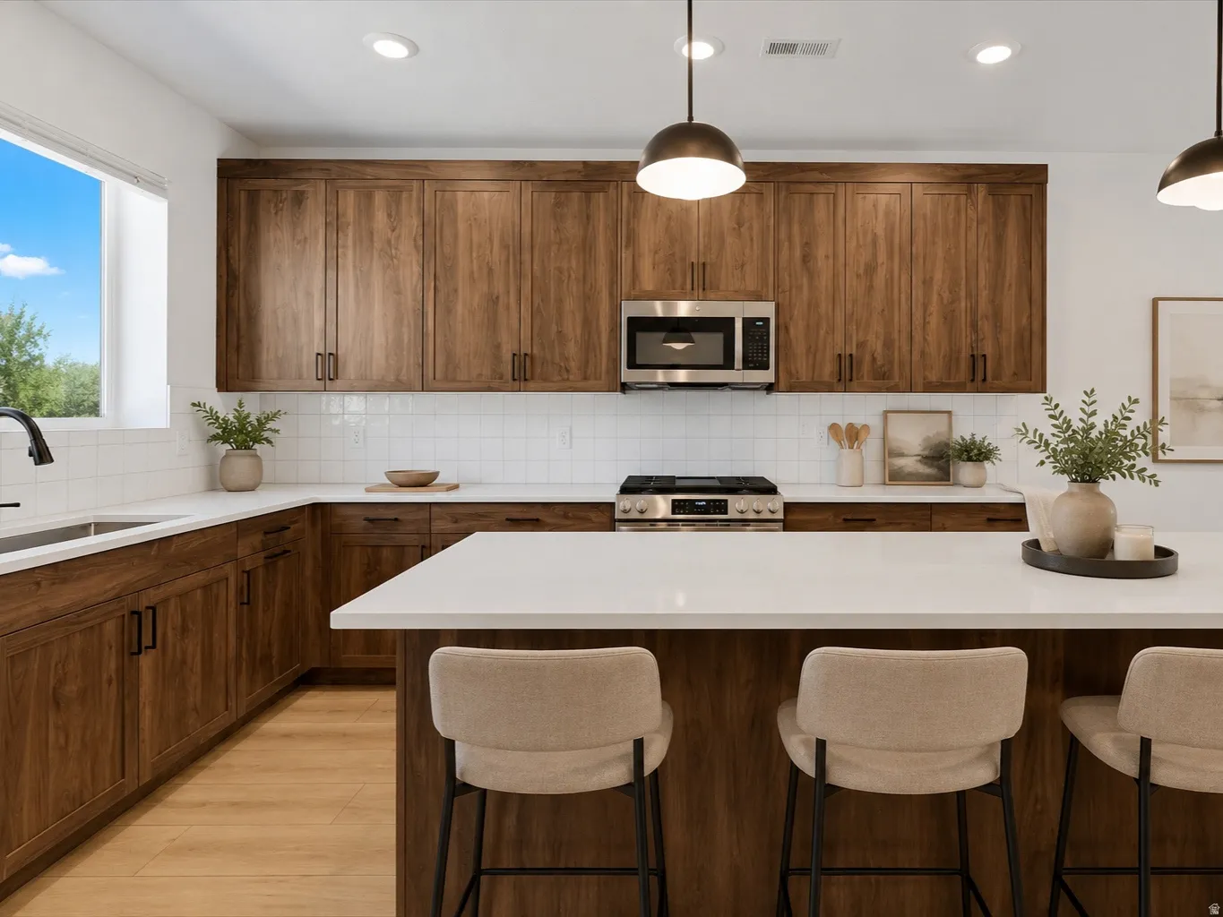 Contemporary kitchen featuring an expansive island with seating, wood-finish cabinetry, stainless steel appliances, a white subway tile backsplash, and a large window above the sink