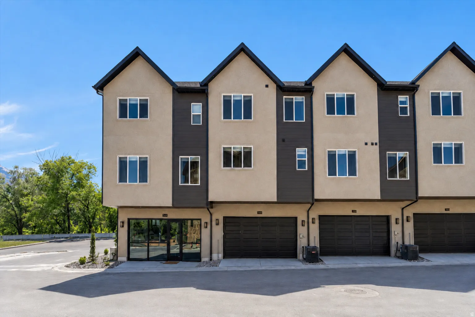 Contemporary townhome exterior featuring a two-tone facade with stucco and dark paneling