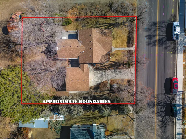 Property featuring a brown shingle roof, established trees, and a concrete driveway
