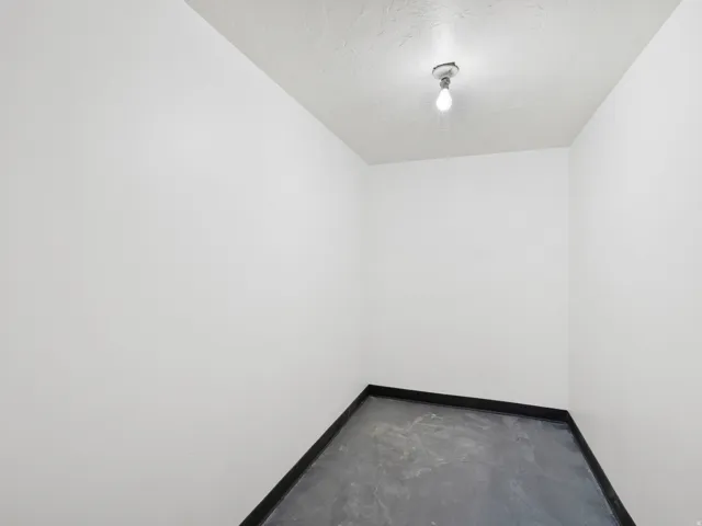 Compact interior space featuring light-toned walls and dark-toned flooring