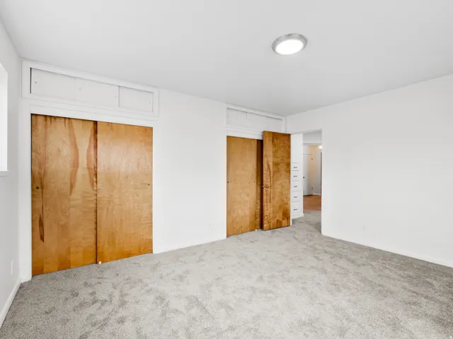 Spacious room featuring light gray carpeting and white walls