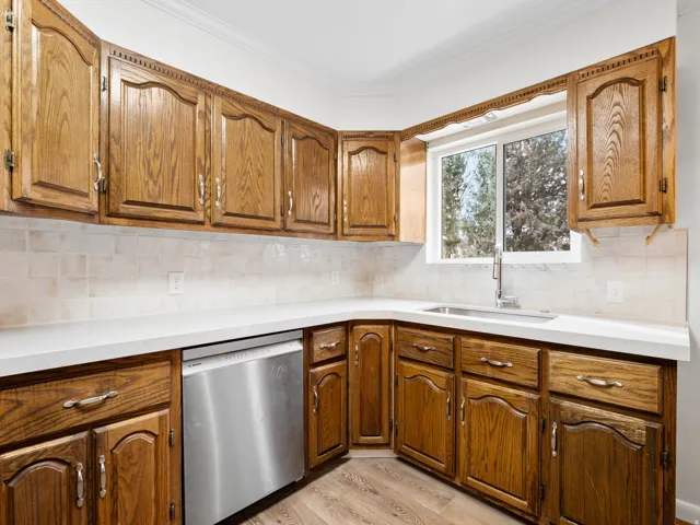 Kitchen featuring wood cabinetry, light countertops, and a tiled backsplash