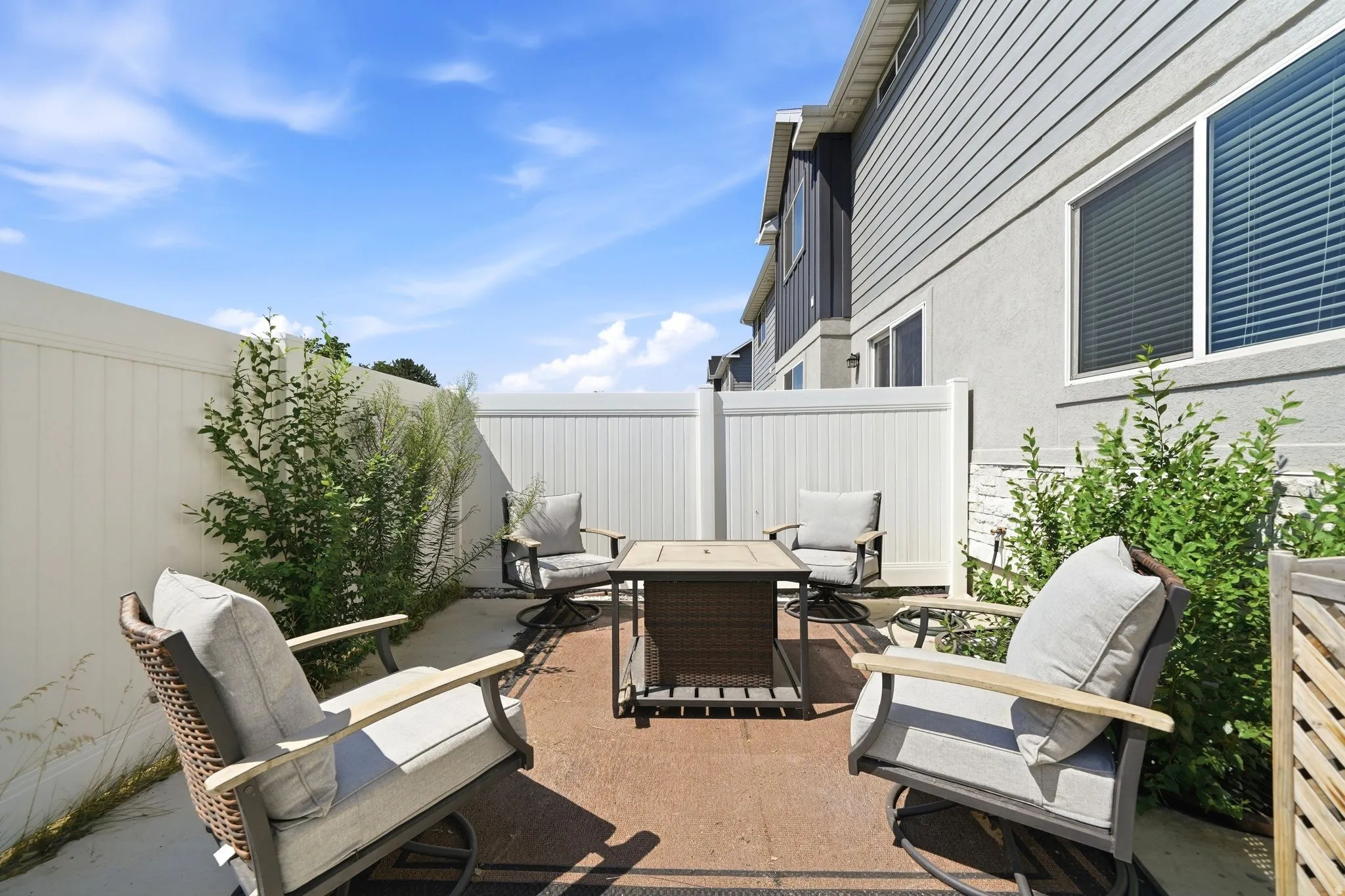 Private outdoor patio featuring a concrete surface, perimeter fencing, and established shrubbery
