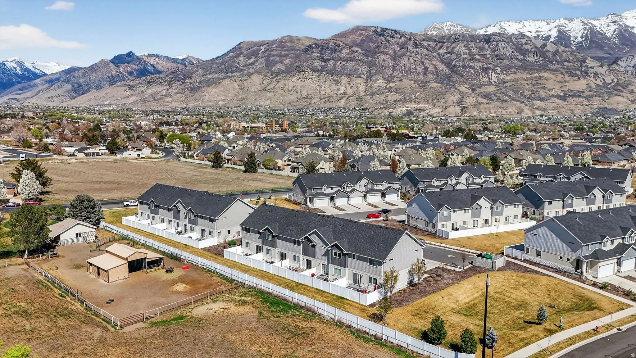 Modern townhomes featuring light-toned siding, dark roofing, and individual balconies