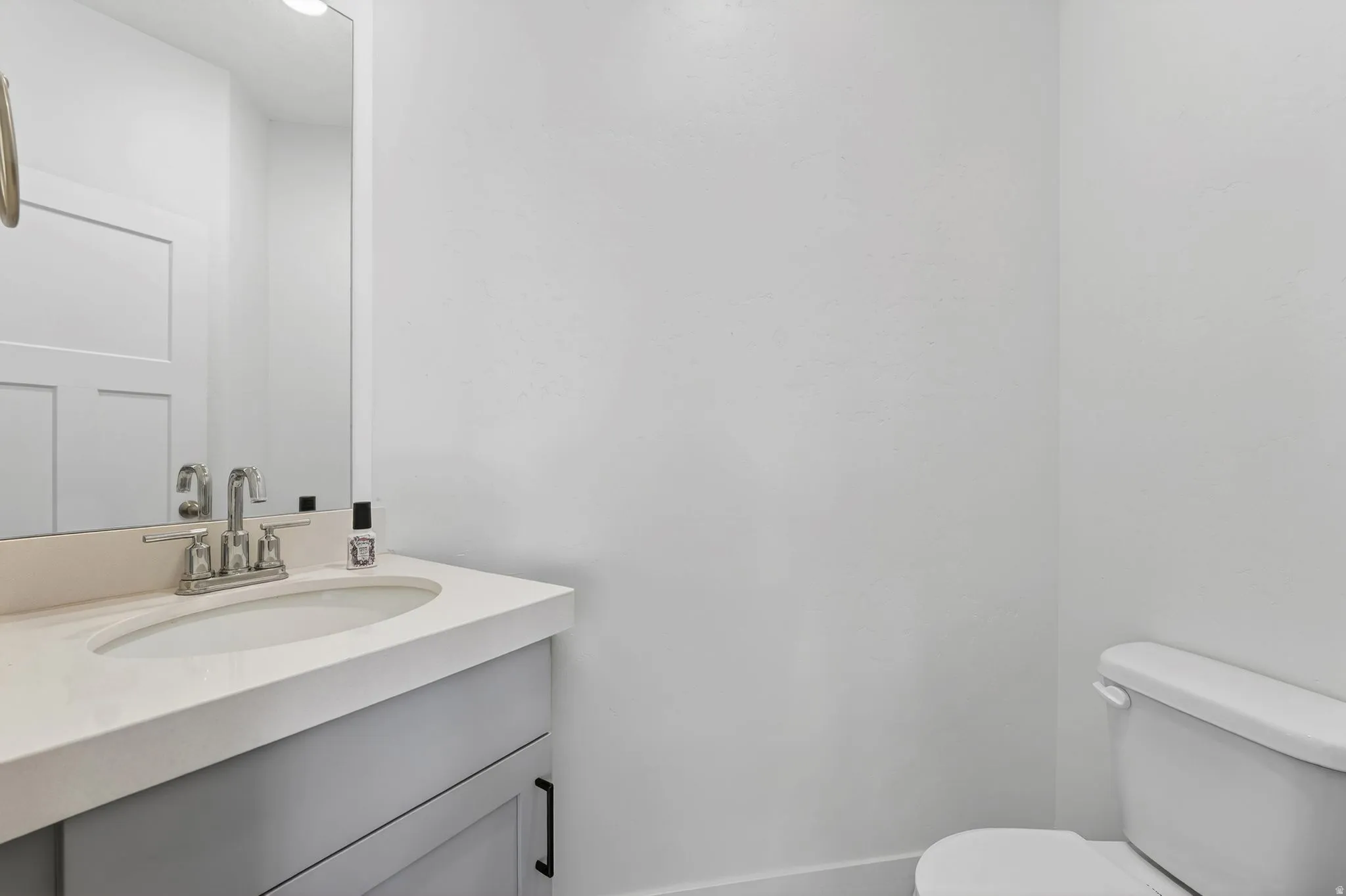 Vanity featuring a light countertop, undermount sink, and brushed nickel faucet