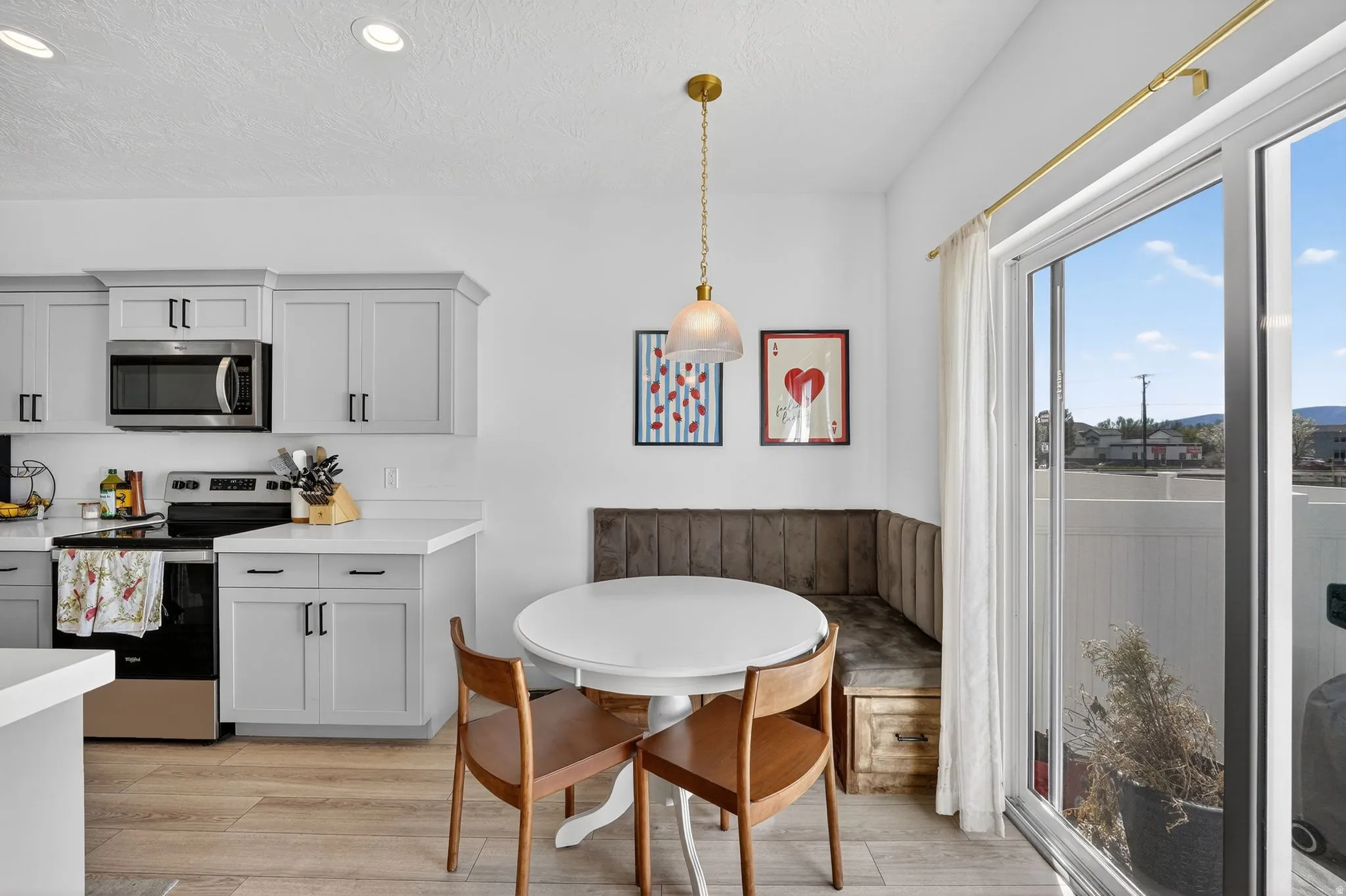 Contemporary kitchen featuring light gray cabinetry, stainless steel appliances, and white countertops
