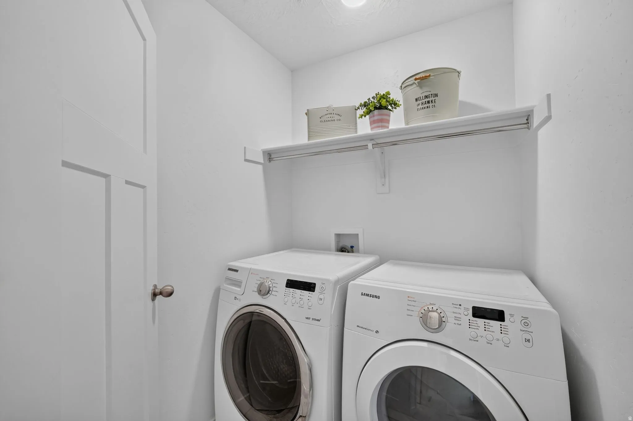 Dedicated laundry area featuring a built-in white shelf and white walls