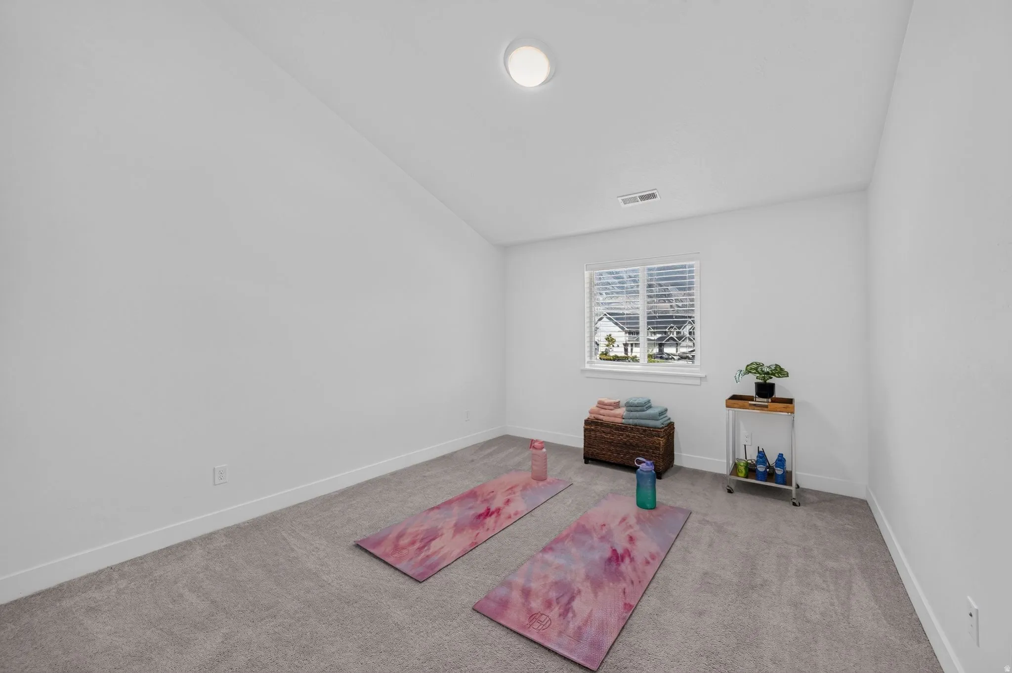 Carpeted room with a single window and recessed lighting