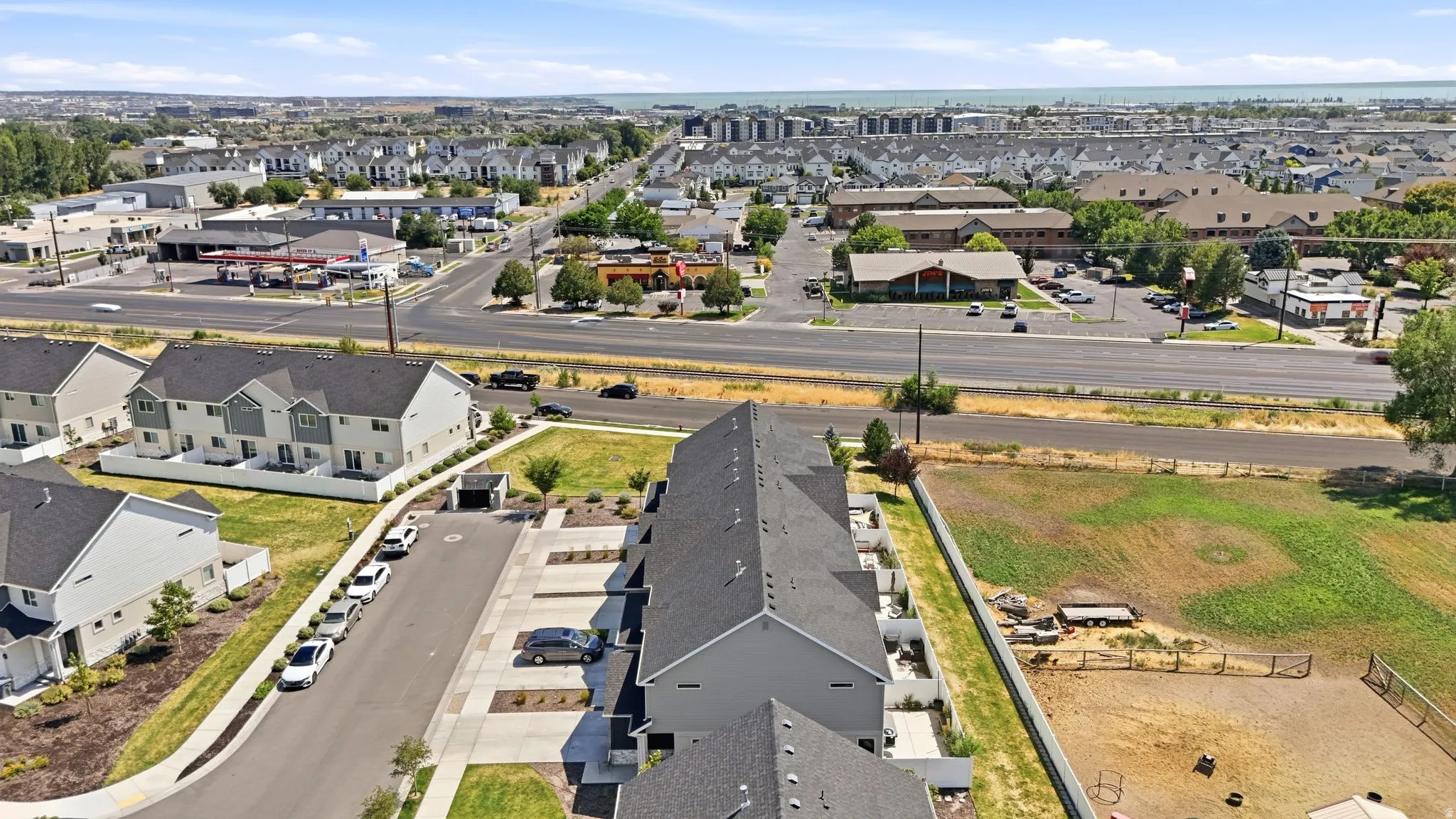 Townhome community featuring multi-level residences with contrasting light and dark siding, dark shingle roofs, and private balconies
