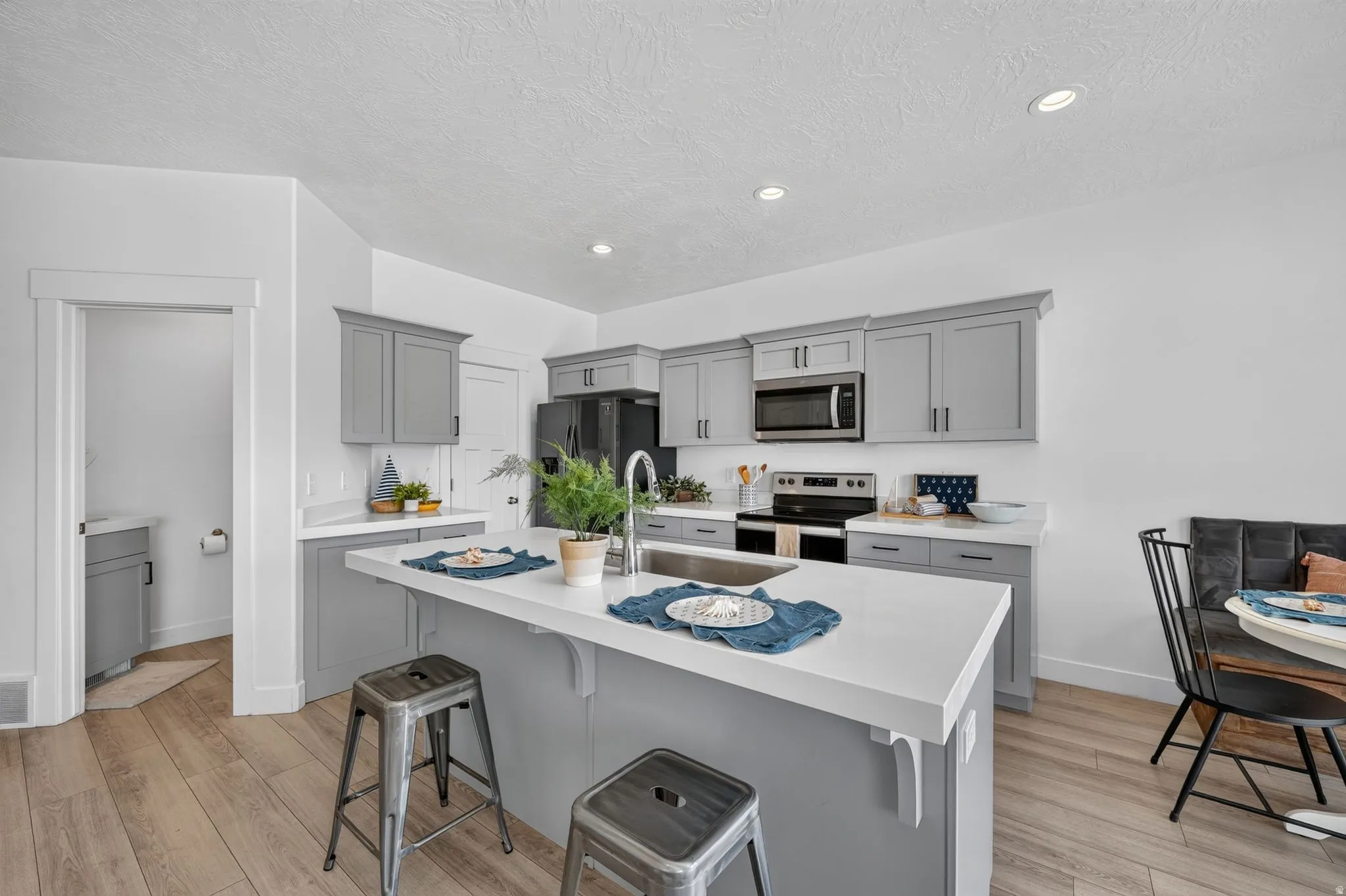 Contemporary kitchen featuring a central island with an integrated sink and breakfast bar seating