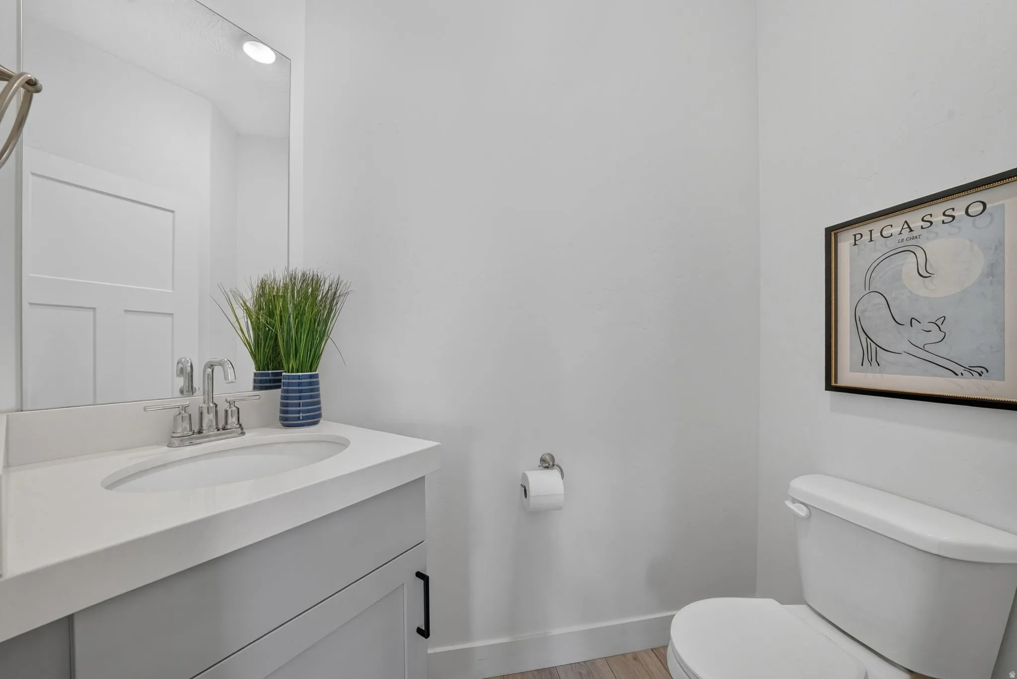 Powder room featuring a single vanity with a light gray cabinet, white countertop, and an undermount sink