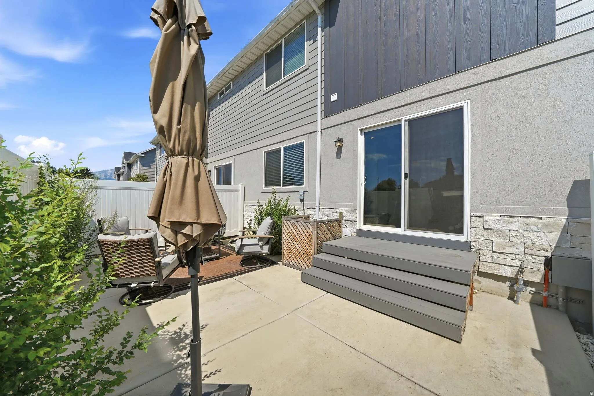 Private patio area featuring a concrete surface and a tiered deck