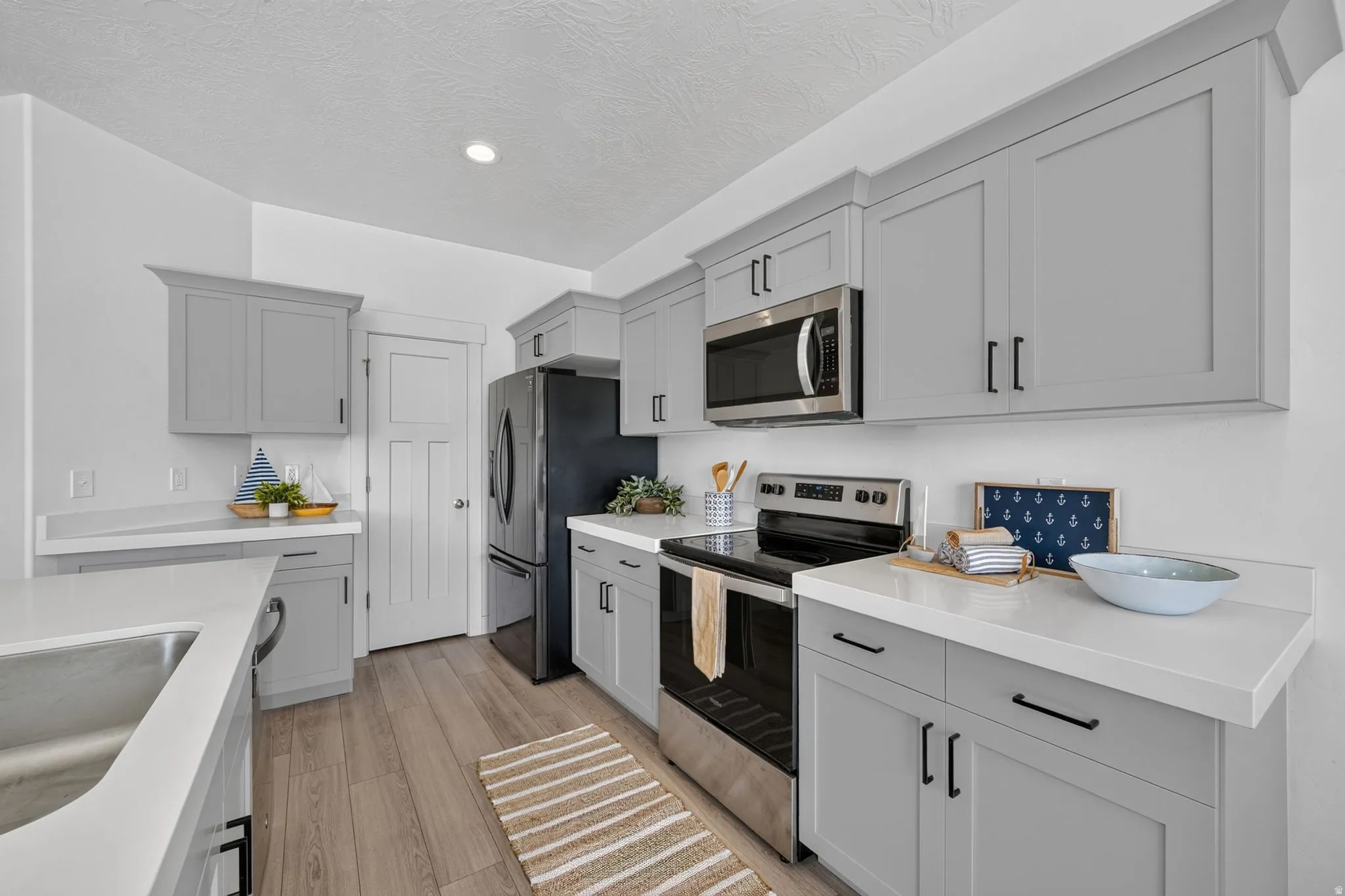 Modern kitchen featuring gray shaker-style cabinetry with matte black hardware