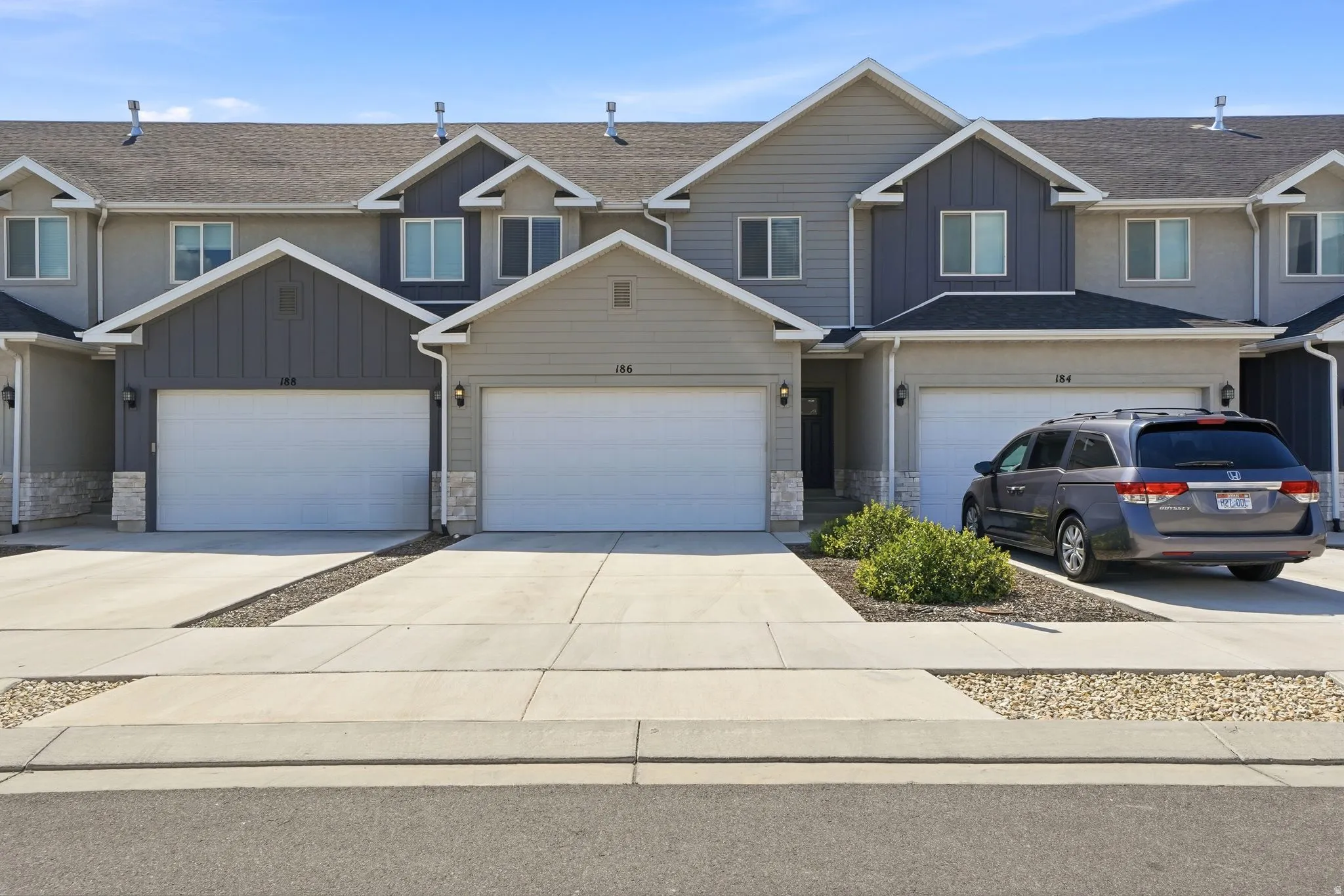 Contemporary townhouse exterior featuring a multi-tone facade with stone accents and vertical siding