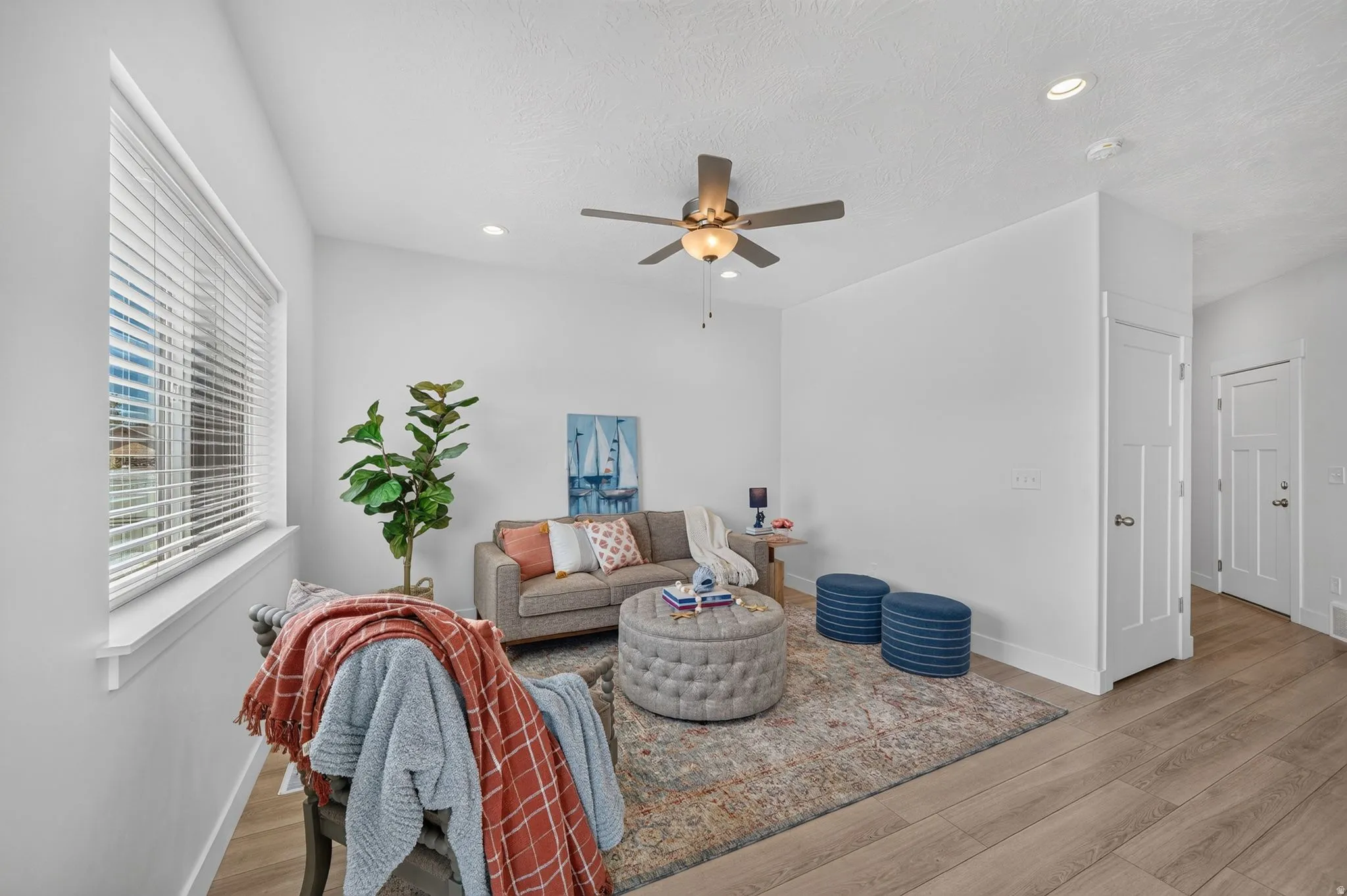 Spacious living area featuring expansive windows, recessed lighting, and wood-finish flooring