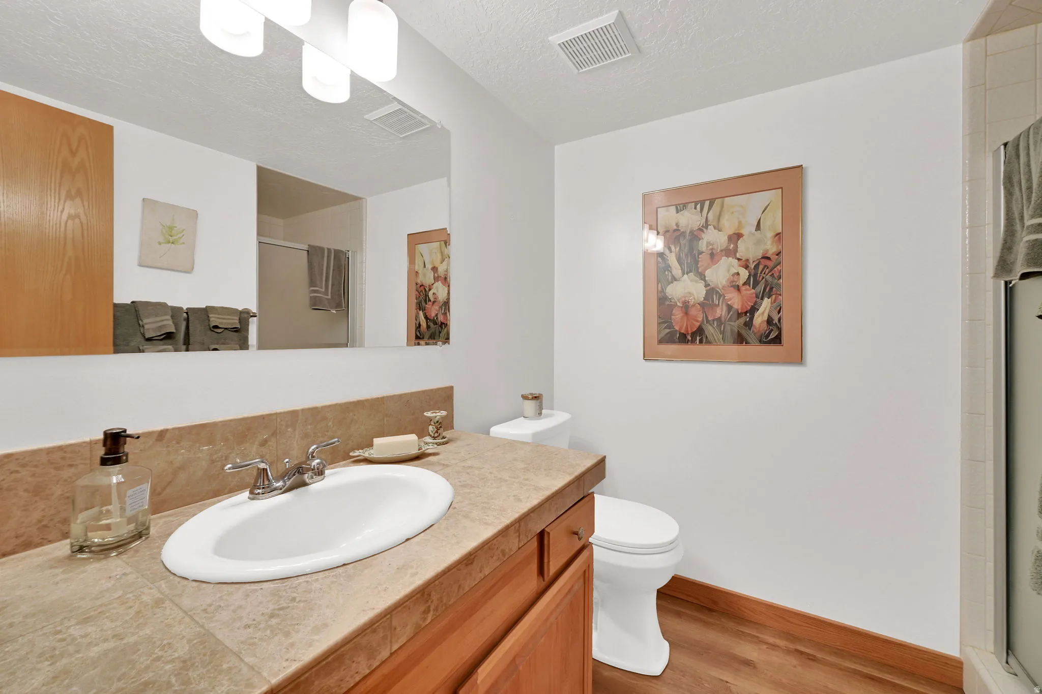 Bathroom featuring a vanity with a drop-in sink, chrome faucet, and a stone-look countertop