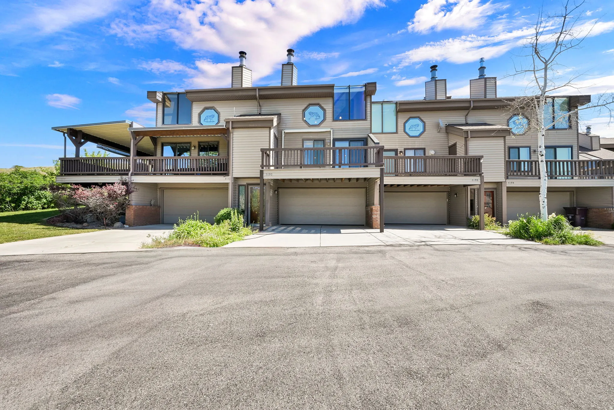 Multi-level townhome exterior featuring private balconies and integrated garage parking