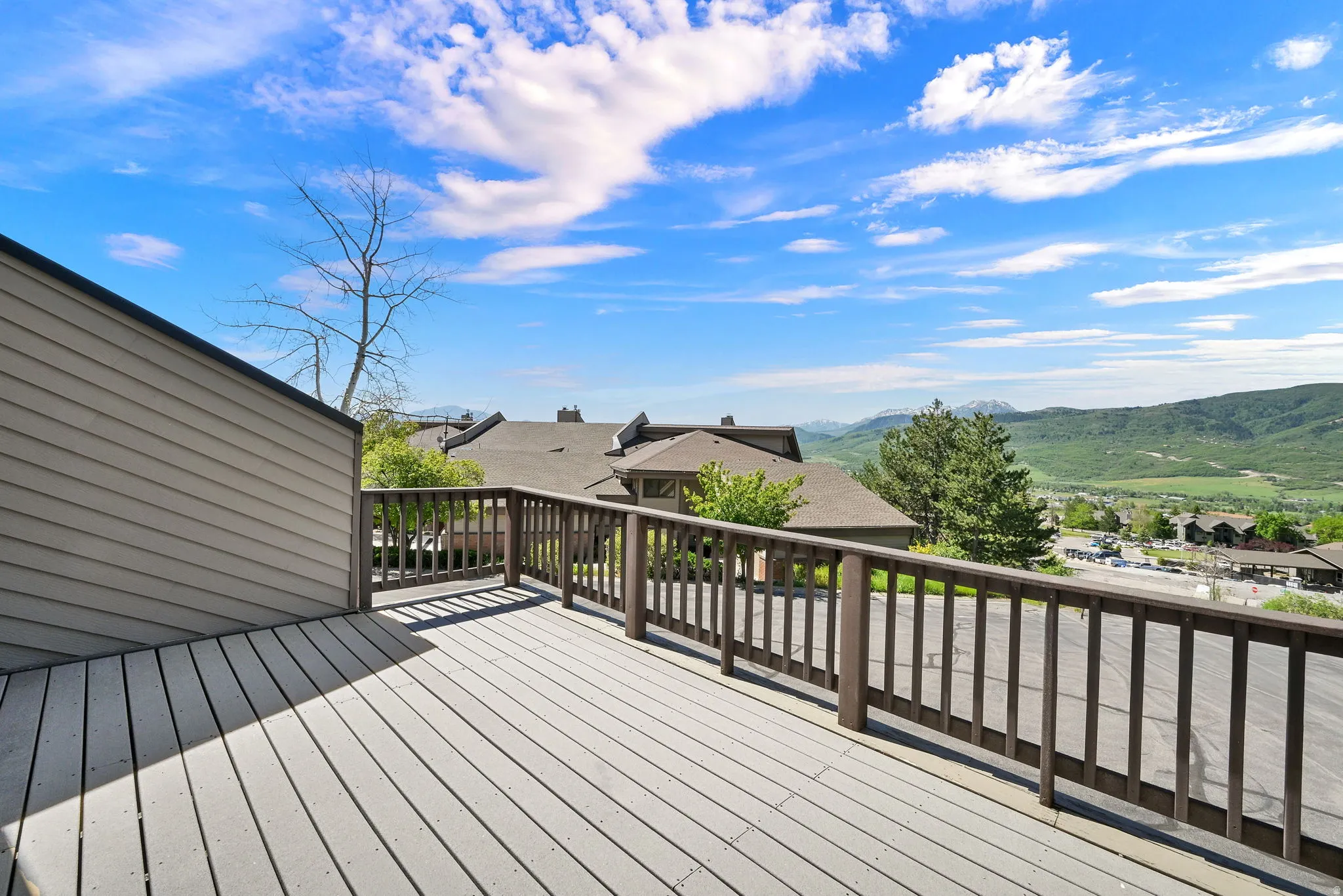 Expansive outdoor deck featuring wood-finish flooring and a wood railing