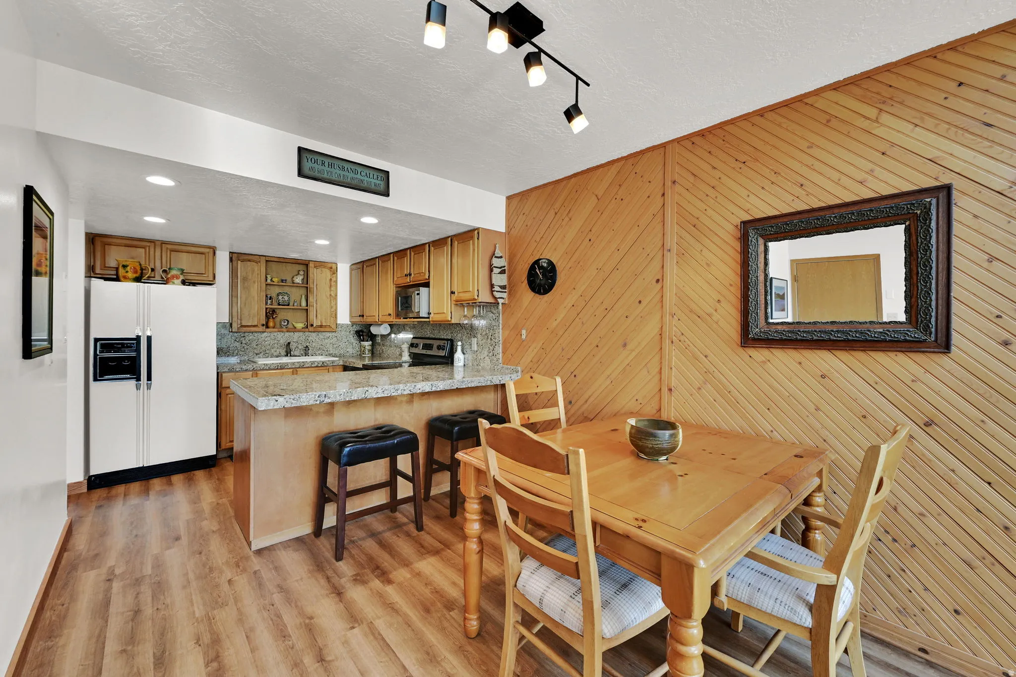Open-concept kitchen and dining area featuring wood-finish flooring