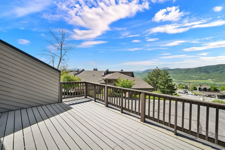 Expansive outdoor deck featuring wood-finish flooring and a wood railing