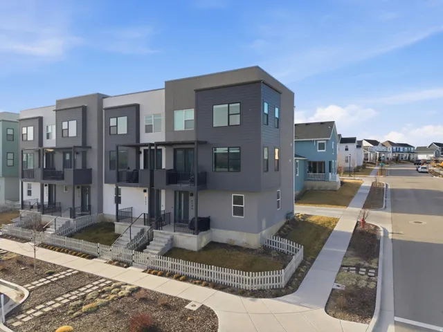 Contemporary multi-level townhome featuring a modern facade with contrasting siding and multiple private balconies